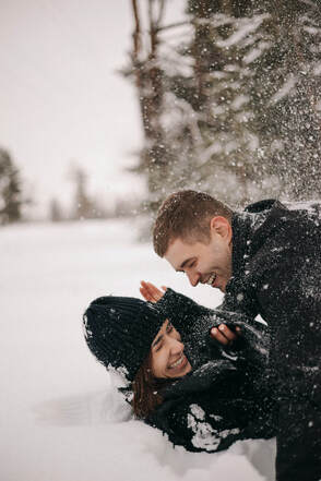 Couple playing and laughing in the snow.